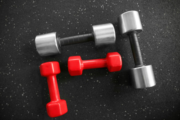 Different dumbbells on floor in gym