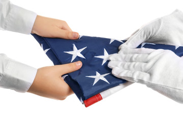Hands holding folded American flag on white background