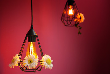 Lamps decorated with flower garland on purple background