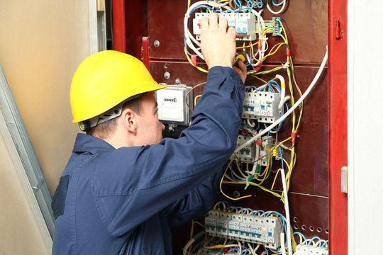 Electrician connecting wires in distribution board