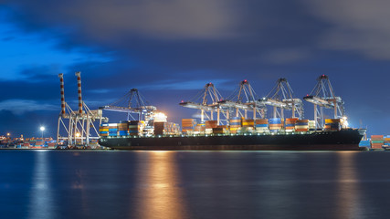 Container ship in import, export port against  twilight