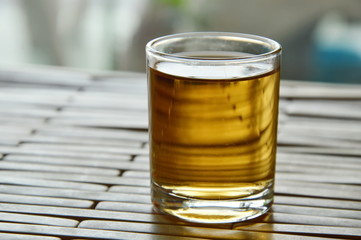 hot tea in little glass on bamboo plate