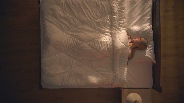 The sleeping woman lay on the bed. View from above