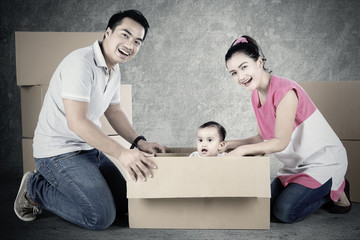 Cheerful parents and child play with box
