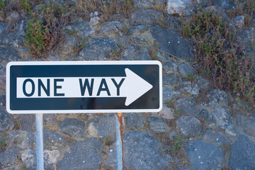 Dark wall with One Way streetsign traffic direction