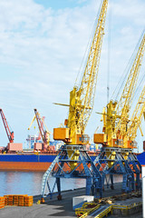 Obraz premium Bulk cargo ship under port crane
