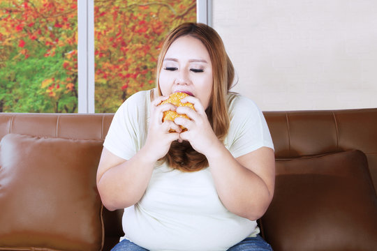 Fat woman looks hungry on couch