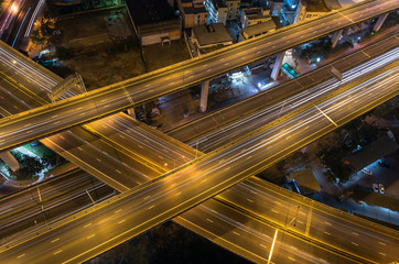 Top view of massive expressway at night with light of cars, tran