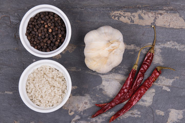 Course gray salt, peppercorns, garlic ad dried red peppers on g