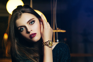 Close up portrait of a young beautiful fashionable woman touching her face. Model looking at...