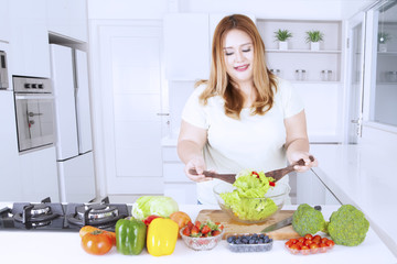 Obraz na płótnie Canvas Obese woman making healthy salad