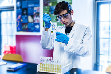Young scientist examining chemical sample in a laboratory. Medical laboratories research operation.