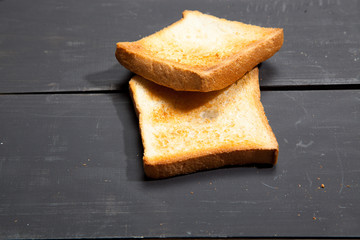 Toast the bread on a black wooden background