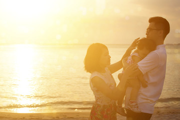 Family enjoying holiday vacation on seaside in sunset