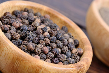 Black peppercorns in a bowls on table