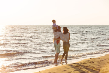 happy young family have fun on beach run and jump at sunset