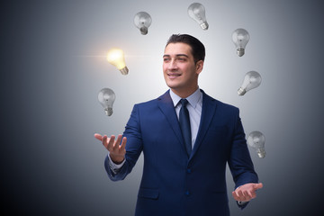 Businessman juggling lightbulbs in new idea concept