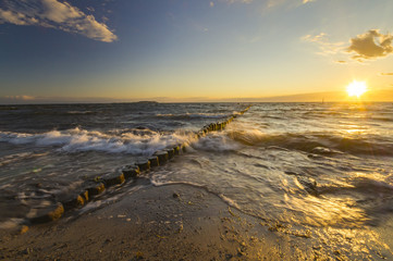 sea landscape, waves breaking on the breakwater pile of wood, baltic sea

