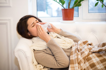 sick girl lying on the couch with a runny nose