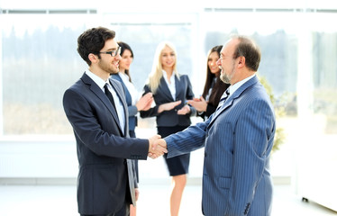Meeting of two business partners at the presentation, greeting with a handshake