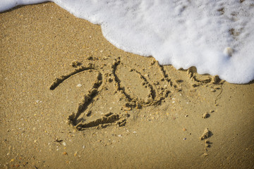 Abstract 2018 on a beach sand background