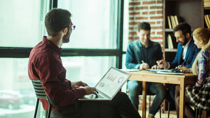 commercial Director working with financial graphs on the laptop 