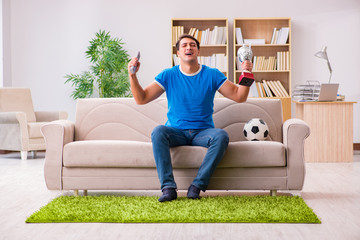 Man watching football at home sitting in couch