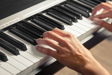 Fototapeta premium Closeup of hands playing piano. Music and hobby concept