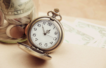 Money saving concept with vintage clock for the past.
