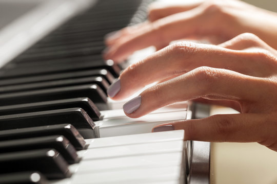 Closeup of hands playing piano. Music and hobby concept
