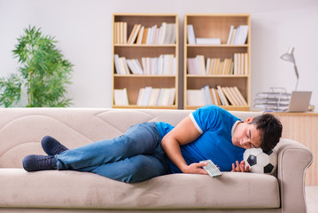 Man watching football at home sitting in couch