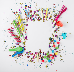 Frame with confetti, balloons, noisemakers and decoration on whi