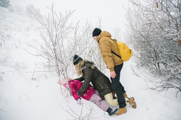 cheerful family playing on snow in winter