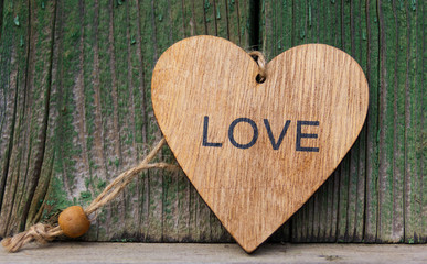 Wooden heart on a background of the old wall.The village heart Valentine's Day. Symbol of love. Valentine's day concept background. 