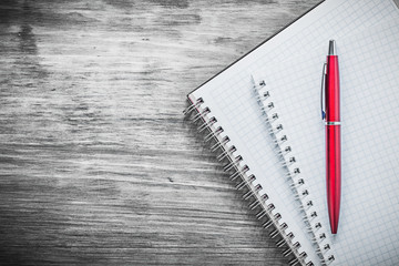 Squared clean notepads ball-point pen on wood board office conce