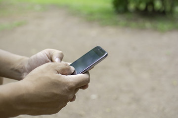 Close up of a man using mobile smart phone outdoor, in hand
