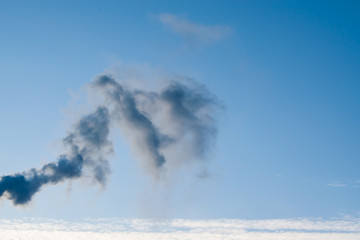 Black smoke from chimney on blue sky background