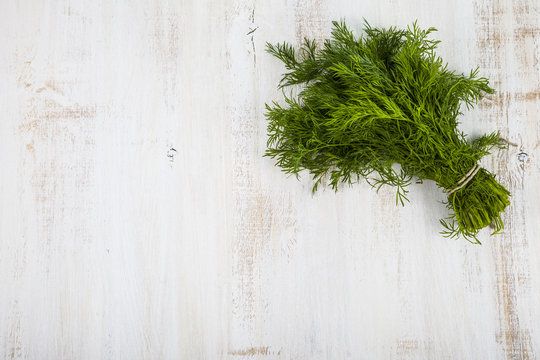 Fresh dill on a light wooden background