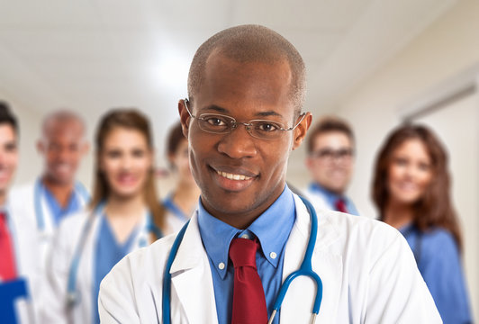 Smiling doctor in front of a group of colleagues