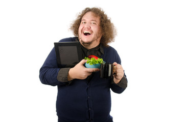 Fototapeta na wymiar Funny guy with a salad and a tablet. Morning, breakfast and diet. Cheerful boy with vegetables and tablet. 