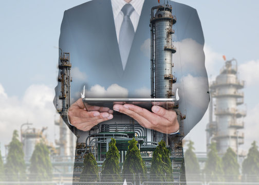 Double exposure of business man hand hold tablet and  Electric Generating Factory at the day as Energy and Technology concept.