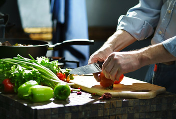 Chef cuts the tomatoes with a knife