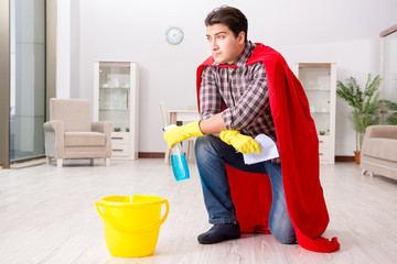 Super hero husband cleaning floor at home