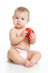 Eight month old baby sitting with apple