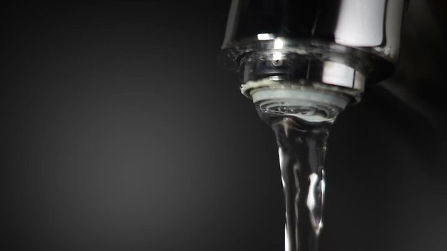 Flowing water from the tap. Super slow motion video.