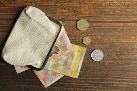 Wallet with money on a wooden background. The concept of poverty.