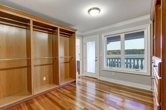 Empty Walk In Closet With Hardwood Floor And Door To Balcony