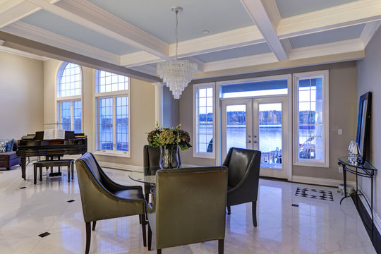 Luxury home interior features dining space with coffered ceiling
