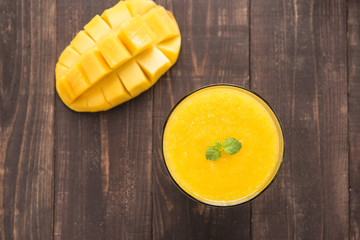 Top shot mango smoothie and mango on wooden table