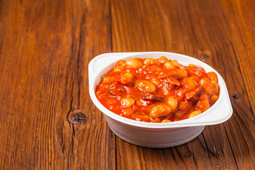 Baked beans in tomato sauce served in plastic cups.